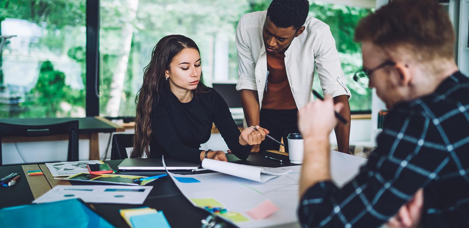 A group of business professionals discuss strategy around a table.