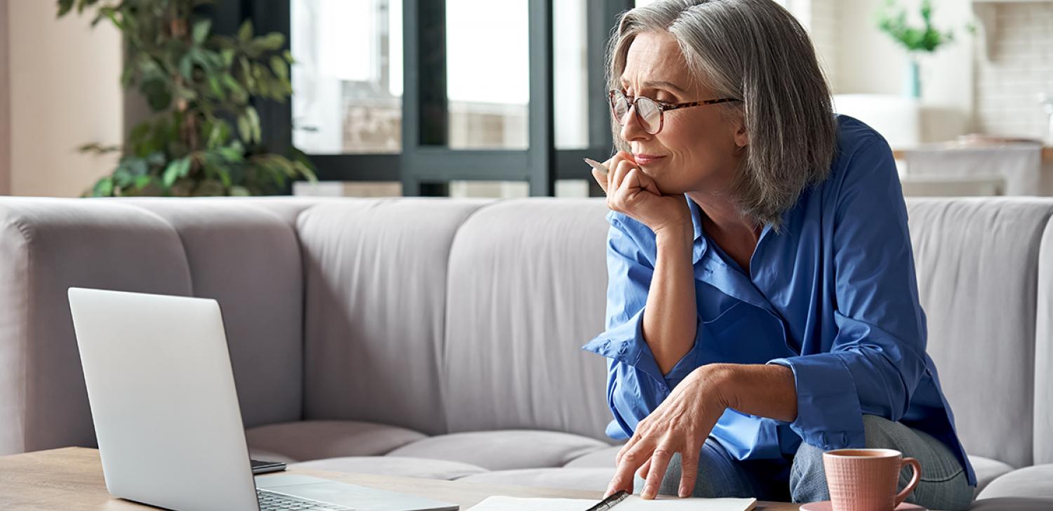 An entrepreneur researches training opportunities on a laptop.