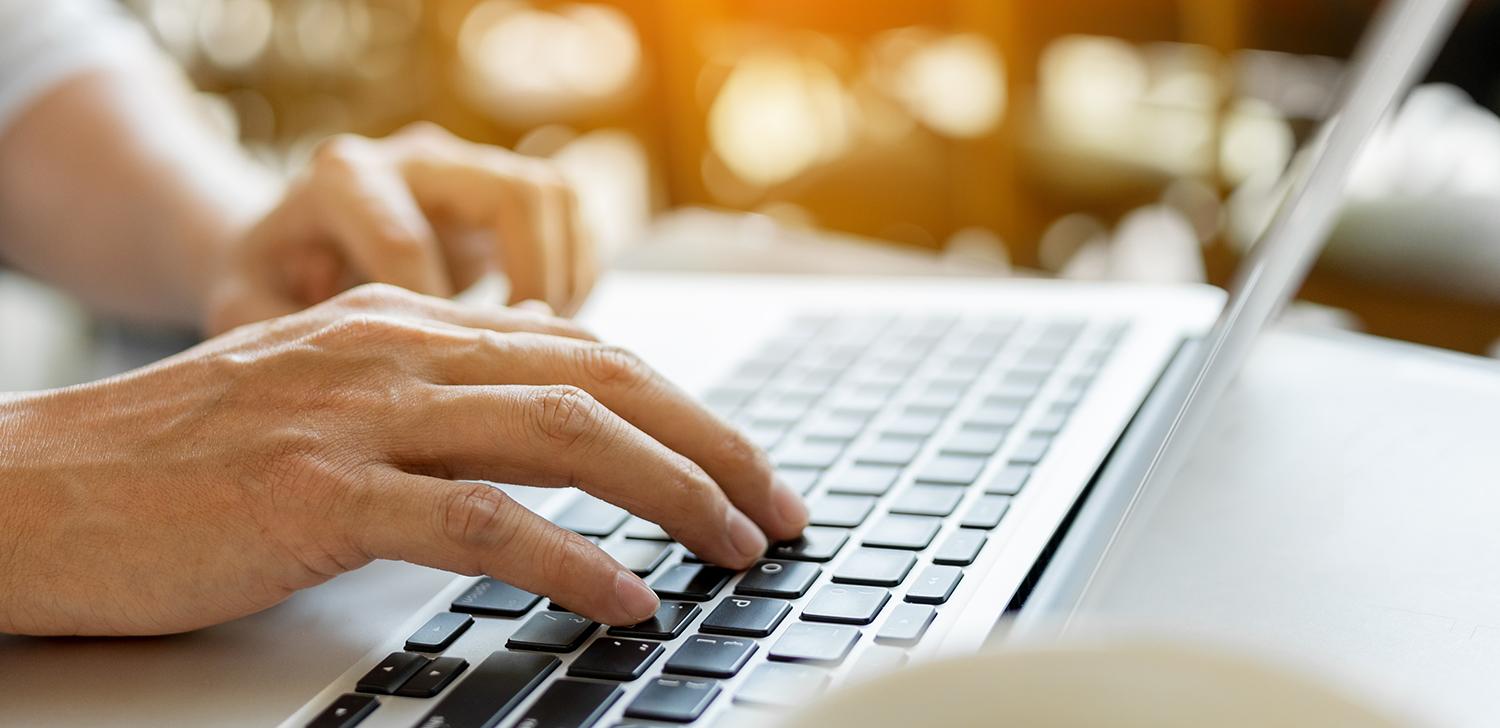 Hands typing on a laptop.