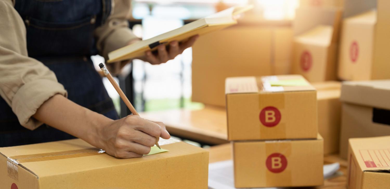 A person writing on a packaging.