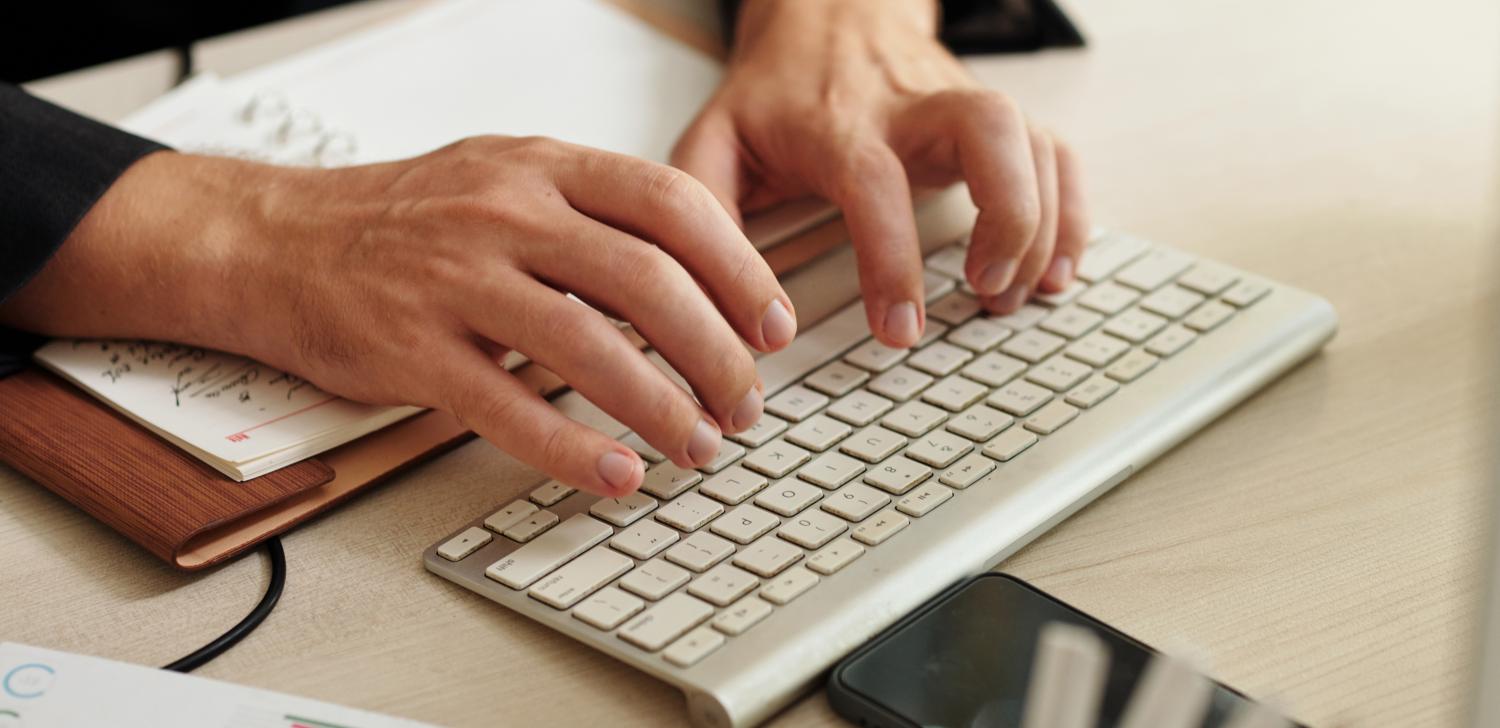 man's hands typing on keyboard