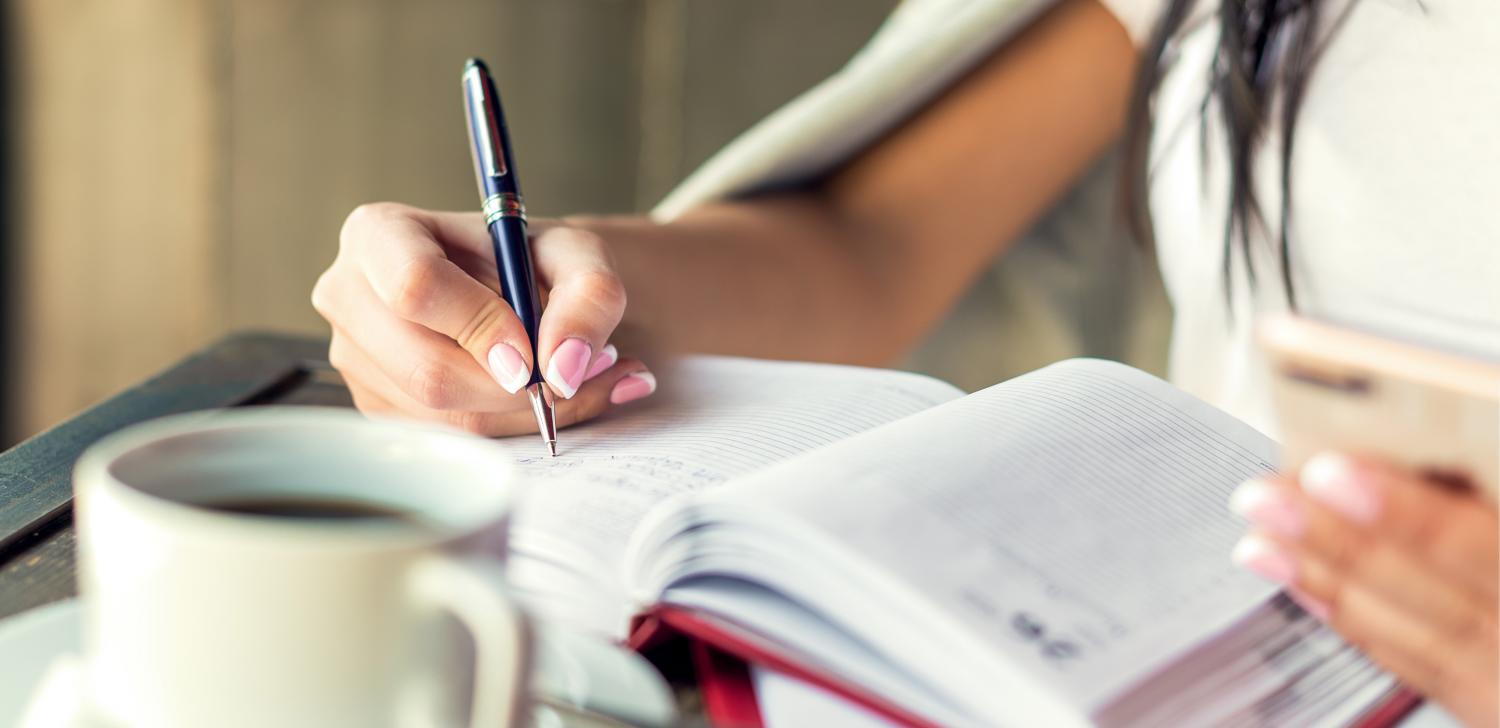 Woman's hand writing in planner 