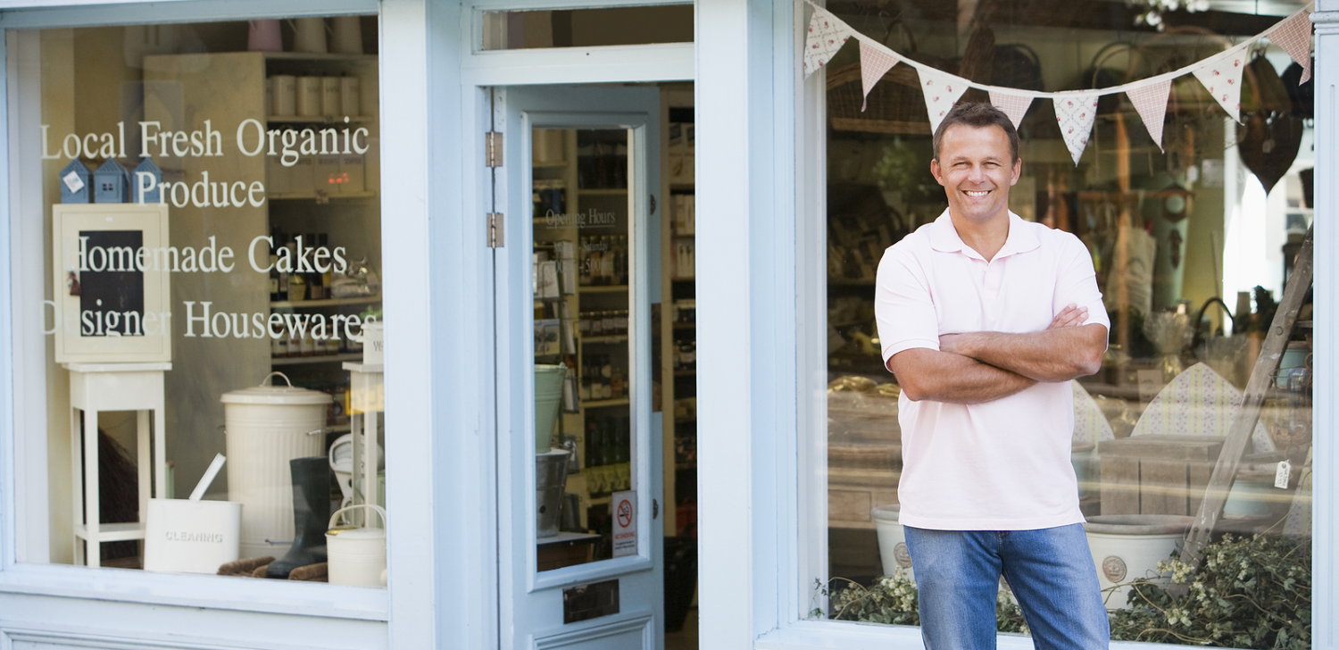 Man stating in front of small business storefront.