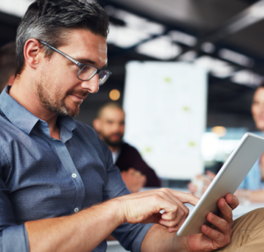 Man at Office Looking at a Tablet Thumbnail